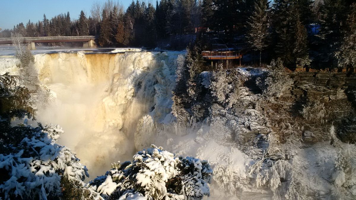 large waterfall in winter with boardwalks on side