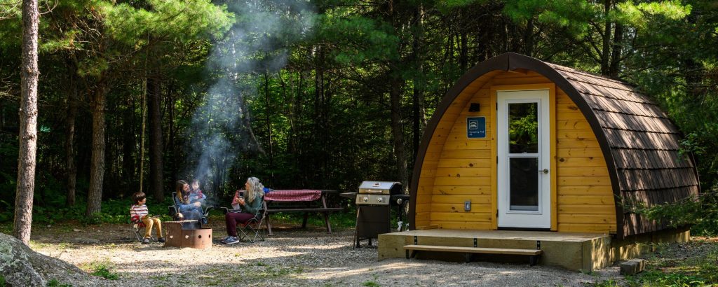 camping pod with group having campfire outside
