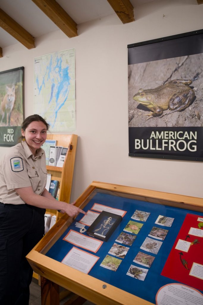 Abby Brown inside visitor centre, pointing at display