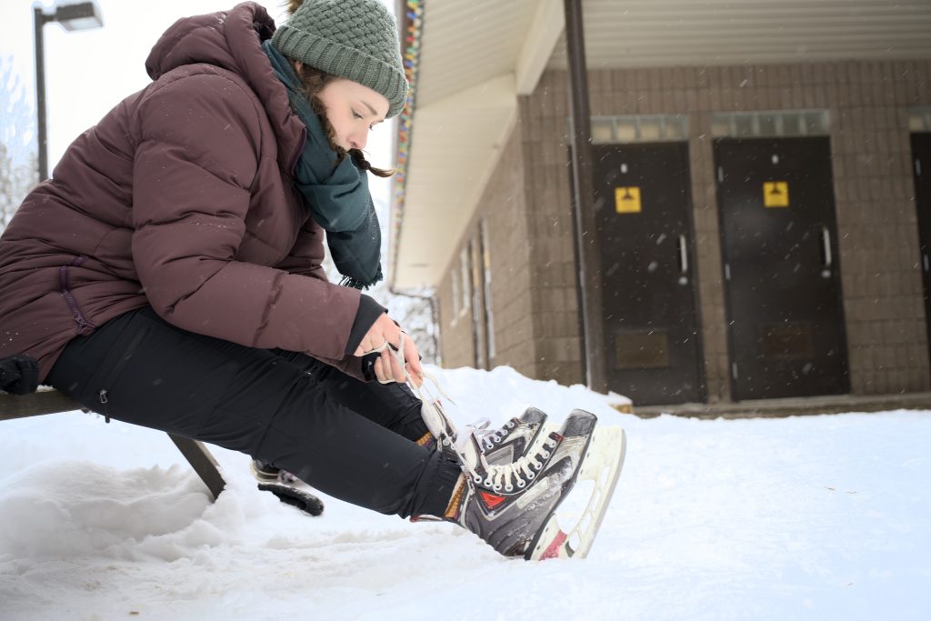 person lacing up skates near comfort station