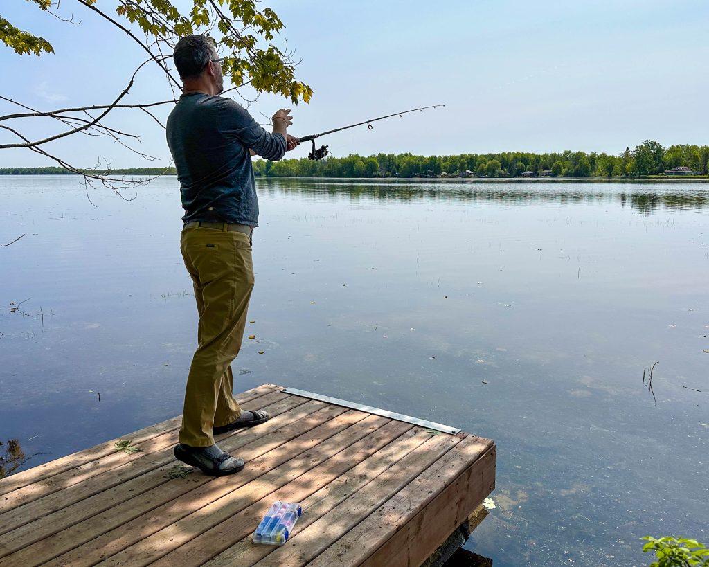 Person fishing off the edge of a dock. 