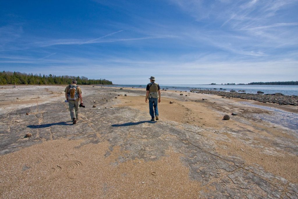 two hikers walking across alvar coast