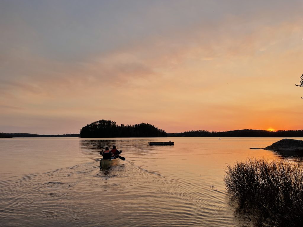 two people paddling on lake at sunset