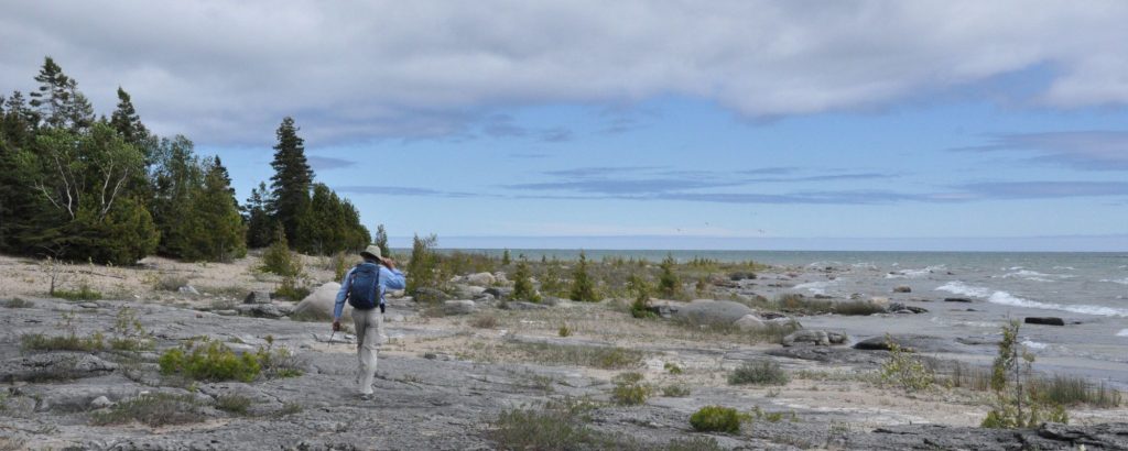 person walking along rocky beach