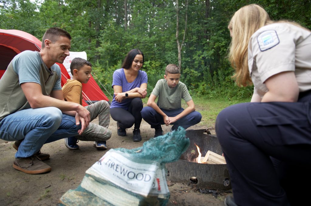 staff showing family how to build a fire
