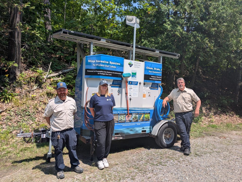 staff from Invasive Species Centre and Ontario Parks standing with boat wash station