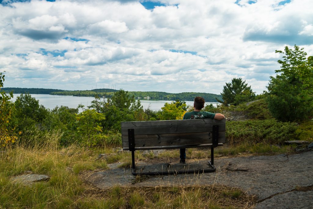 man on bench overlooking lake