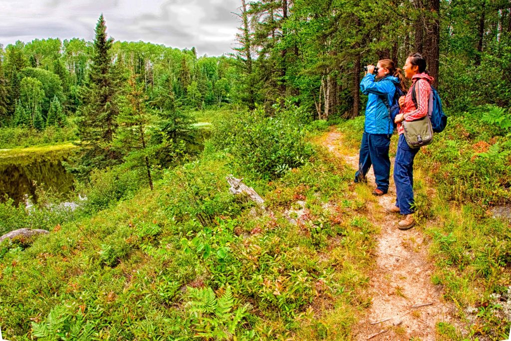 two people on trail looking out at lake