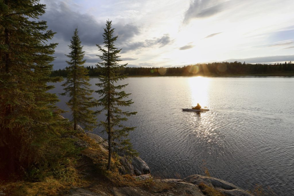 paddler on lake at dusk